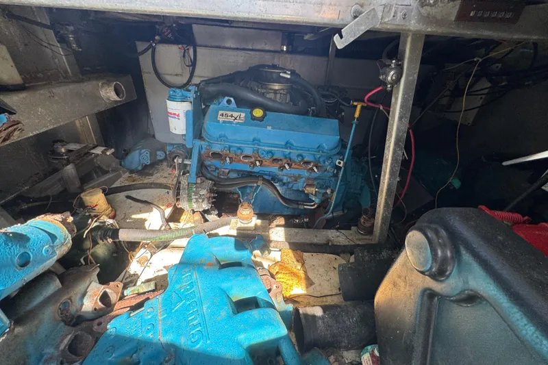 Slide: The Image of Engine room of a 1997 Monticello River Yacht, featuring a blue marine engine. - 28