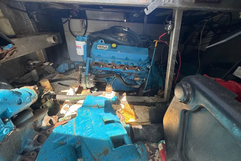 Slide: The Image of Engine room of a 1997 Monticello River Yacht, featuring a blue engine. - 29