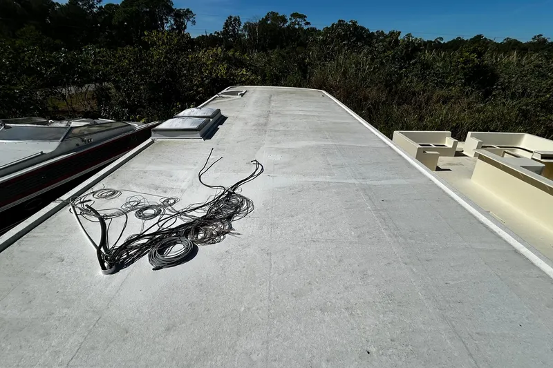 Slide: The Image of Rooftop view of a 1997 Monticello River Yacht, showing coiled cables and open deck space. - 32