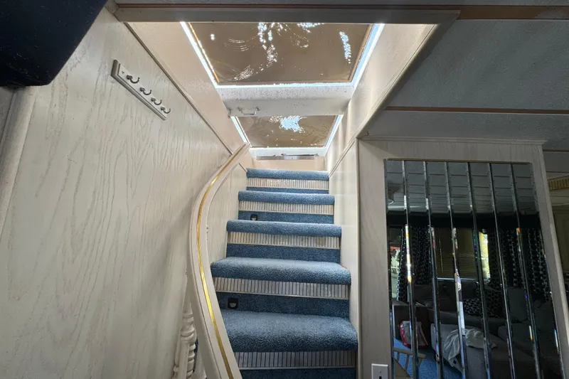 Slide: The Image of Interior staircase of 1997 Monticello River Yacht, featuring blue carpet and mirrored wall. - 6