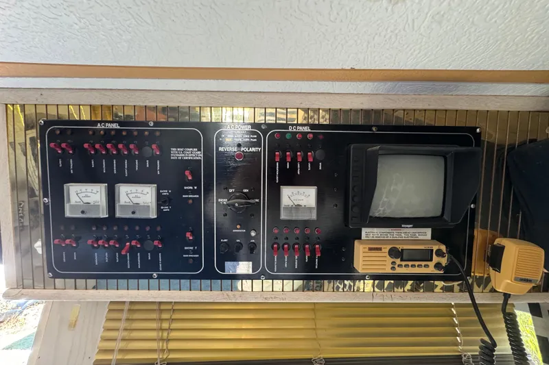 Slide: The Image of Control panel of a 1997 Monticello River Yacht, featuring AC/DC switches and meters. - 7