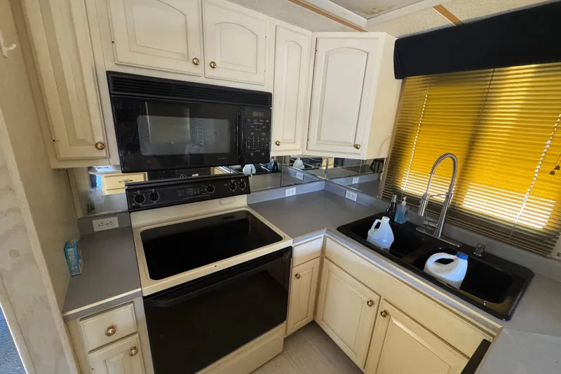 Slide: The Image of Kitchen area of a 1997 Monticello River Yacht with stove, microwave, and sink. - 9
