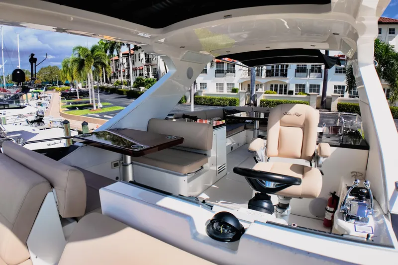 Slide: The Image of 2016 Sea Ray L590 Fly yacht helm with luxurious seating and modern controls. - 2