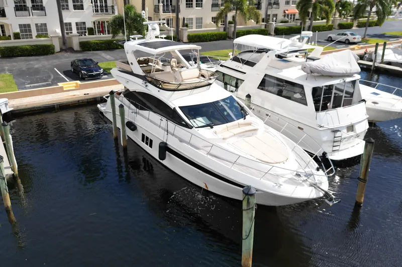 Slide: The Image of 2016 Sea Ray L590 Fly yacht docked at marina, surrounded by other boats. - 27
