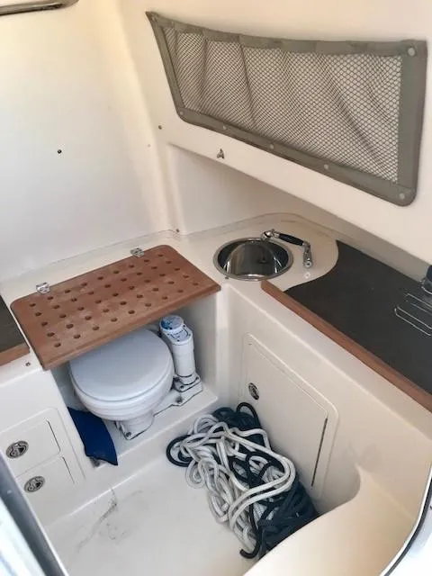 Slide: The Image of 2015 Grady-White Canyon 306 boat interior with sink, toilet, and storage. - 18