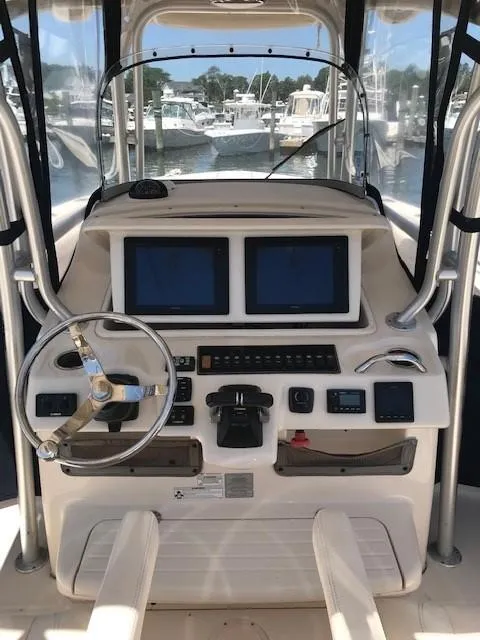 Slide: The Image of 2015 Grady-White Canyon 306 boat dashboard with dual screens and steering wheel. - 8