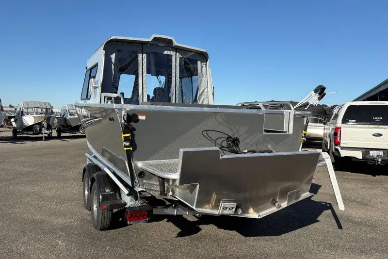 Slide: The Image of 2025 Hewescraft 220 Ocean Pro ET HT boat in a parking lot, rear view. - 2