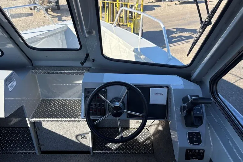 Slide: The Image of 2025 Hewescraft 220 Ocean Pro ET HT boat interior with steering wheel and controls. - 4