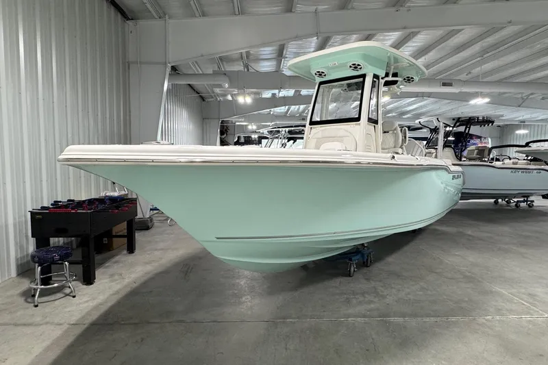 Slide: The Image of 2026 Key West 239 FSR boat in showroom, mint green hull, modern design. - 2