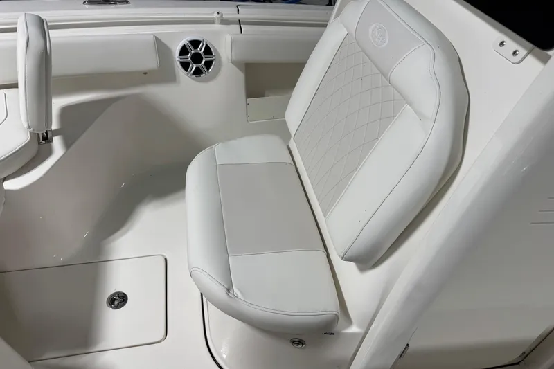 Slide: The Image of 2026 Key West 239 FSR boat interior with white cushioned seating and speaker. - 8