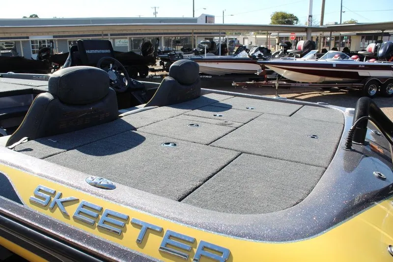 Slide: The Image of 2019 Skeeter ZX225 boat with spacious deck, parked in a marina. - 11