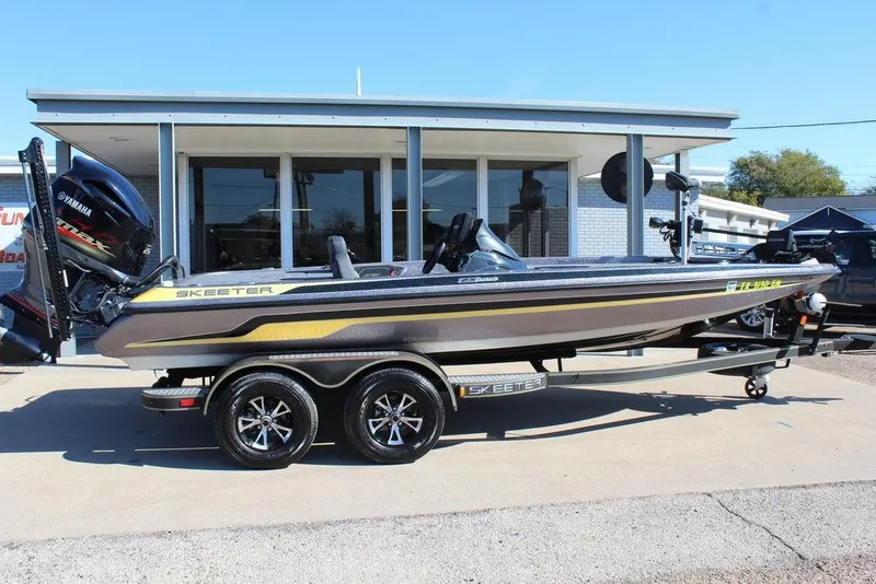 Slide: The Image of 2019 Skeeter ZX225 bass boat with Yamaha engine on trailer, parked outside a building. - 12