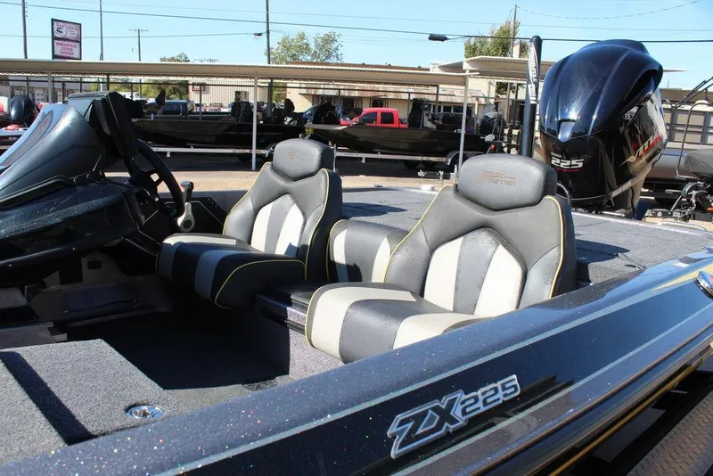 Slide: The Image of 2019 Skeeter ZX225 boat interior with dual seats and steering wheel, parked outdoors. - 21