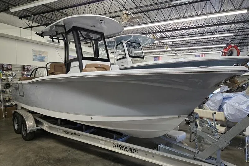 The Image of 2026 Sea Hunt Ultra 245 SE boat on trailer in showroom. - 1