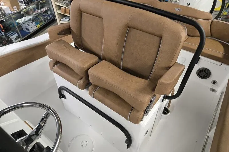 Slide: The Image of 2026 Sea Hunt Ultra 245 SE boat interior with tan seating and steering wheel. - 12