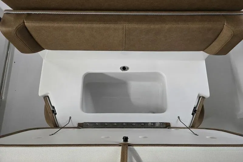 Slide: The Image of 2026 Sea Hunt Ultra 245 SE boat storage compartment with brown cushioned seating. - 19