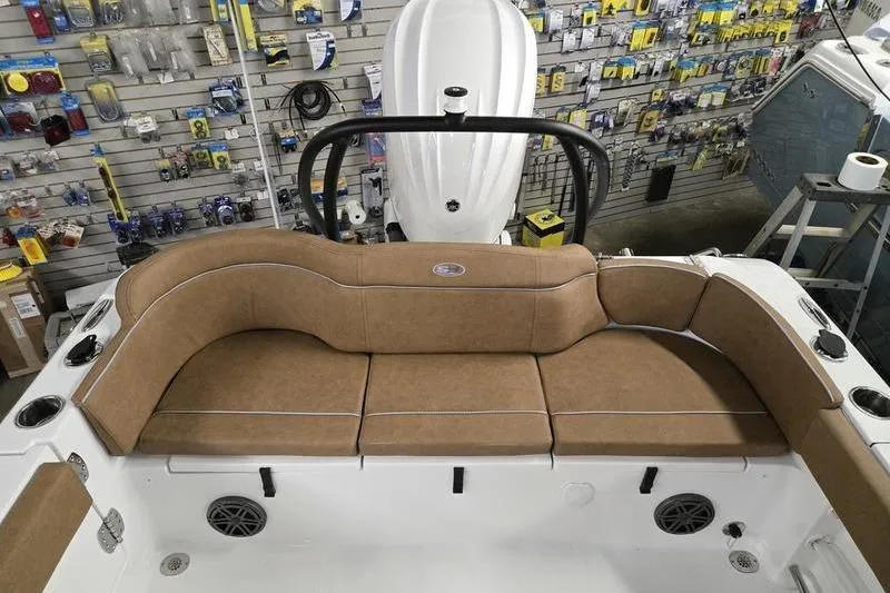 Slide: The Image of 2026 Sea Hunt Ultra 245 SE boat interior with tan seating in a showroom. - 5