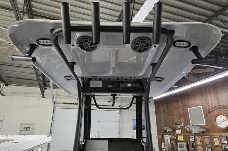 Slide: The Image of 2026 Sea Hunt Ultra 245 SE boat with T-top and rod holders in a showroom. - 9