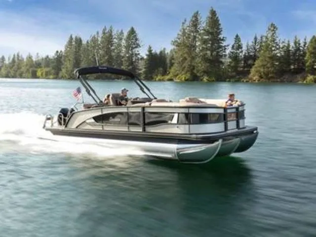 The Image of 2025 Barletta Corsa 23U pontoon boat cruising on a scenic lake. - 0