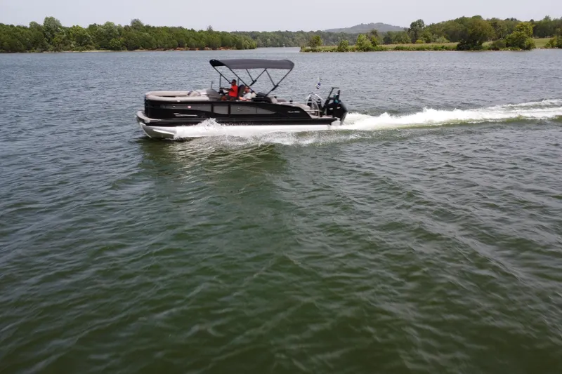 Slide: The Image of 2025 Barletta Corsa 23U pontoon boat cruising on a scenic lake. - 8