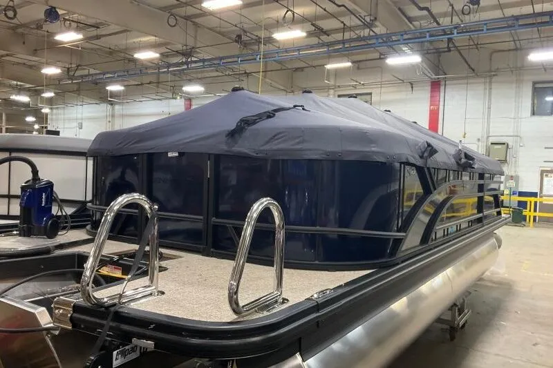 The Image of 2026 Bennington 22 SSRSE pontoon boat with cover in a warehouse setting. - 0