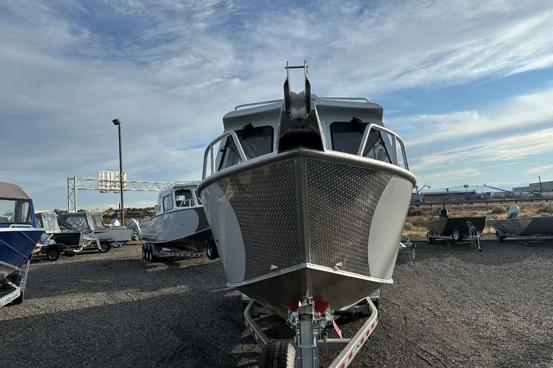 Slide: The Image of 2026 Hewescraft 270 Alaskan boat on trailer, displayed outdoors under a cloudy sky. - 3