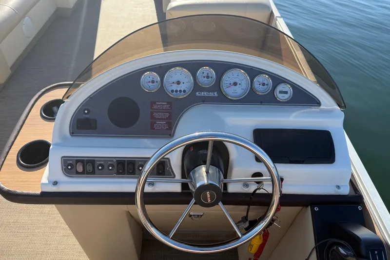 Slide: The Image of 1997 Crest CREST II DLX boat dashboard with steering wheel and gauges. - 16
