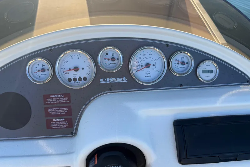 Slide: The Image of Dashboard of a 1997 Crest CREST II DLX boat with Suzuki gauges and warning labels. - 18