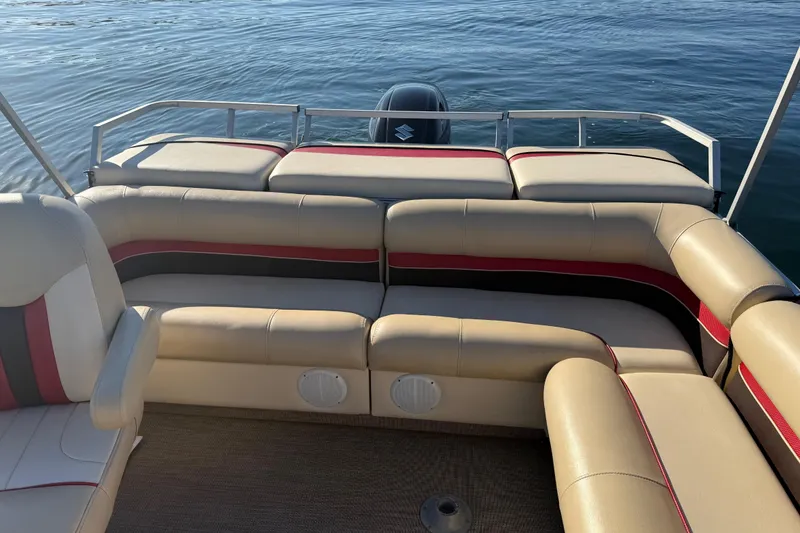 Slide: The Image of 1997 Crest CREST II DLX pontoon boat interior with beige and red seating on calm water. - 28