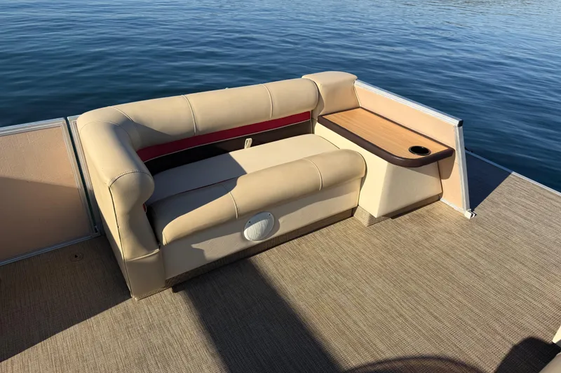 Slide: The Image of 1997 Crest CREST II DLX boat interior with beige seating and wooden side table on calm water. - 33