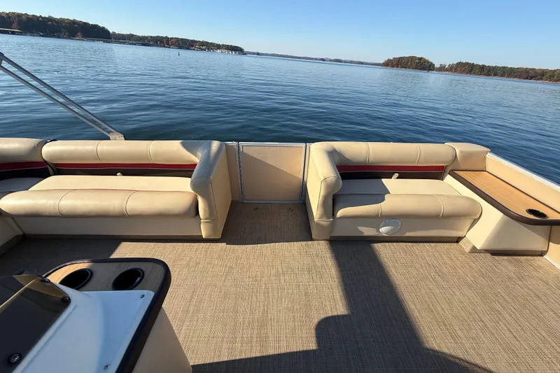 Slide: The Image of 1997 Crest CREST II DLX pontoon boat interior with beige seating on a calm lake. - 34