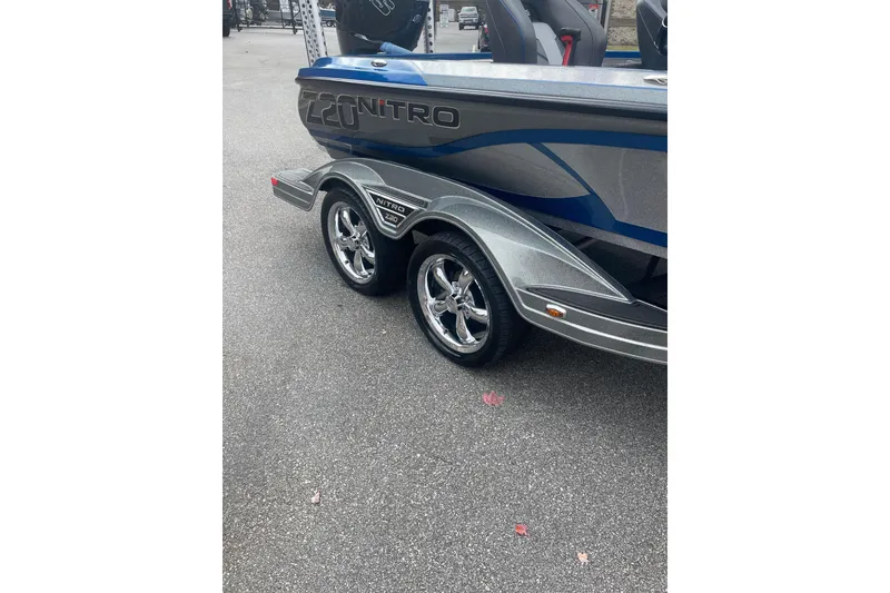 Slide: The Image of 2024 Nitro Z20 boat trailer with chrome wheels on asphalt. - 11