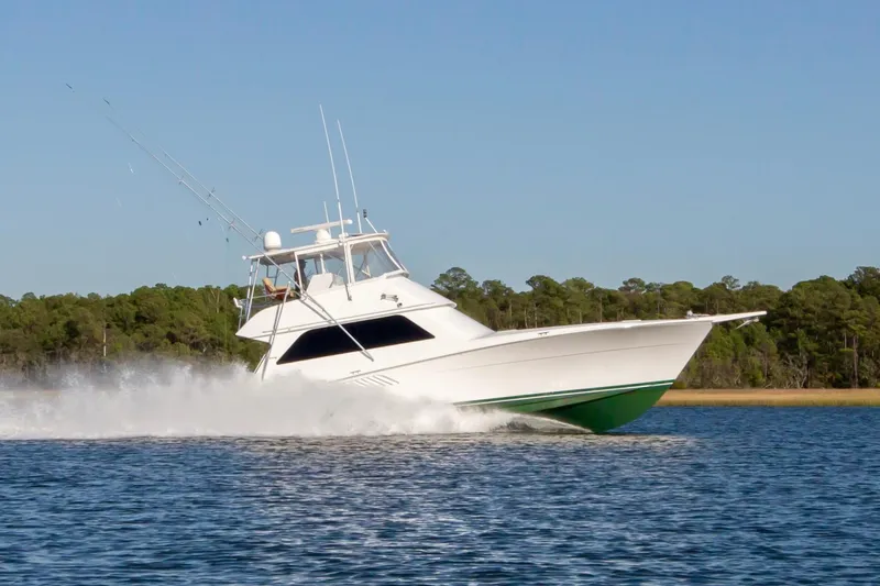 The Image of 2001 Viking 50 Convertible yacht cruising on a calm lake with forested shoreline. - 0