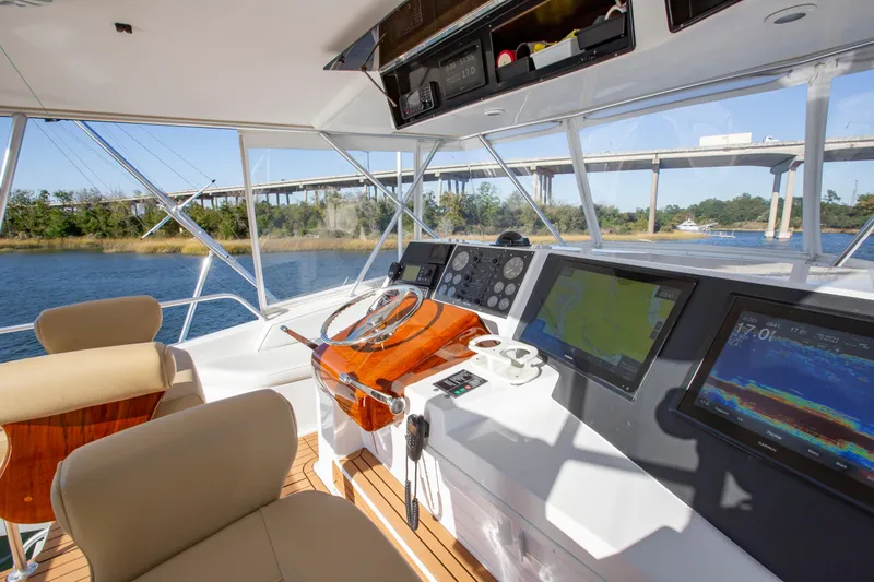 Slide: The Image of Interior view of 2001 Viking 50 Convertible yacht cockpit with navigation screens and steering wheel. - 10