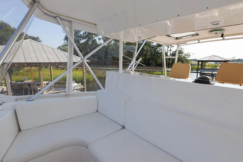 Slide: The Image of Interior view of 2001 Viking 50 Convertible yacht with white seating and scenic marina backdrop. - 12