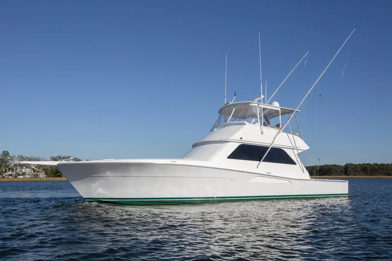 Slide: The Image of 2001 Viking 50 Convertible yacht on calm water under clear blue sky. - 3