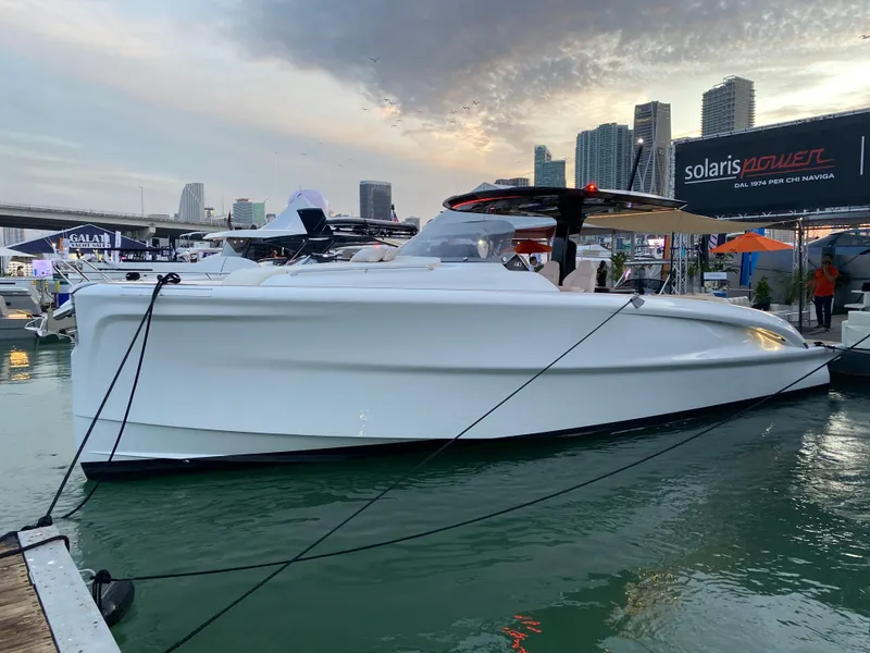 Slide: The Image of 2024 Solaris Power 40 Open yacht docked at marina with city skyline backdrop. - 3