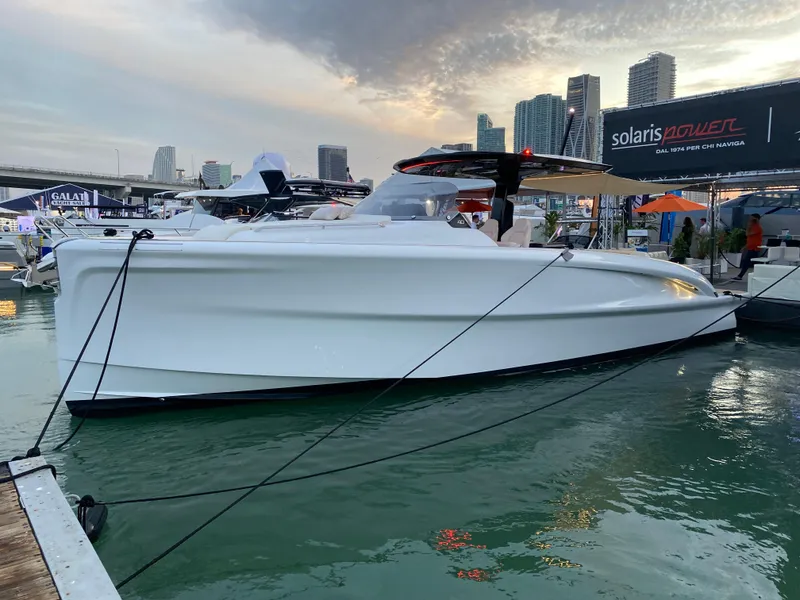 Slide: The Image of 2024 Solaris Power 40 Open yacht docked at marina with city skyline. - 4