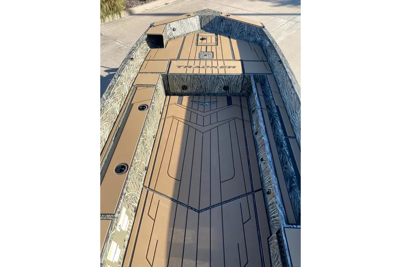 Slide: The Image of 2026 Tracker Grizzly 1756 T Marsh boat interior with camo design and storage compartments. - 3