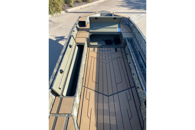 Slide: The Image of 2026 Tracker Grizzly 1756 T Marsh boat interior with storage compartments and camo design. - 5