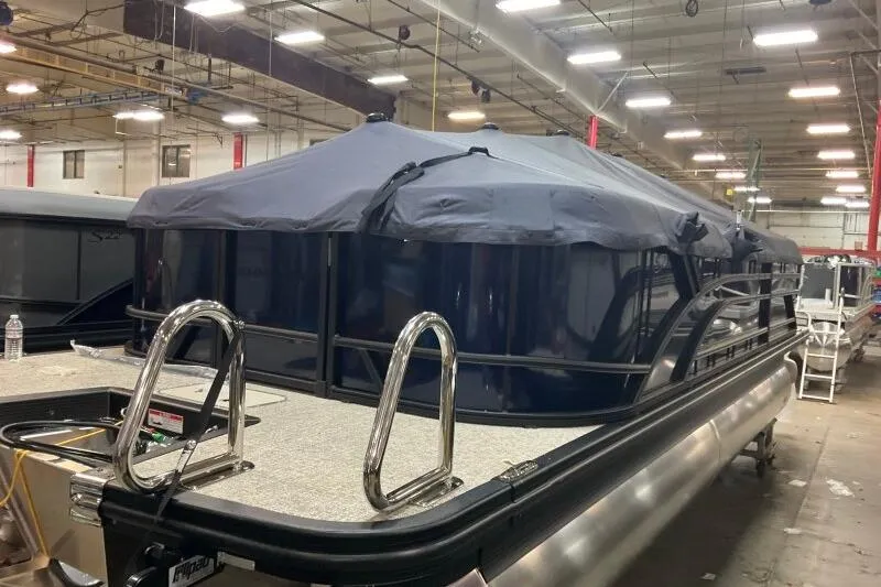 Slide: The Image of 2026 Bennington 22 SSRSE pontoon boat in a warehouse, covered and secured. - 1