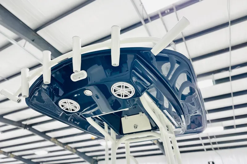 Slide: The Image of 2026 Pathfinder 2200 TRS boat with blue T-top and rod holders in a showroom. - 6