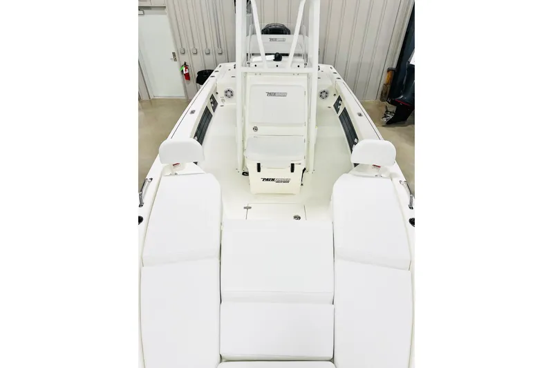 Slide: The Image of 2026 Pathfinder 2200 TRS boat interior with white seating and console in a garage. - 8