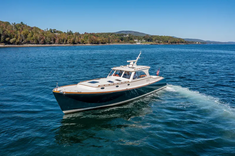 Slide: The Image of 2002 Hinckley Talaria 44 Express yacht cruising on a scenic lake. - 1