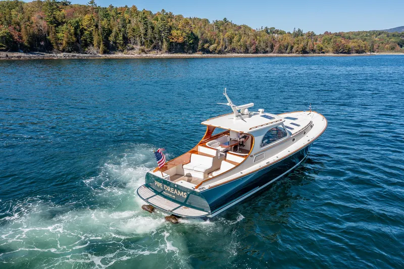 Slide: The Image of 2002 Hinckley Talaria 44 Express yacht cruising on a scenic lake. - 14