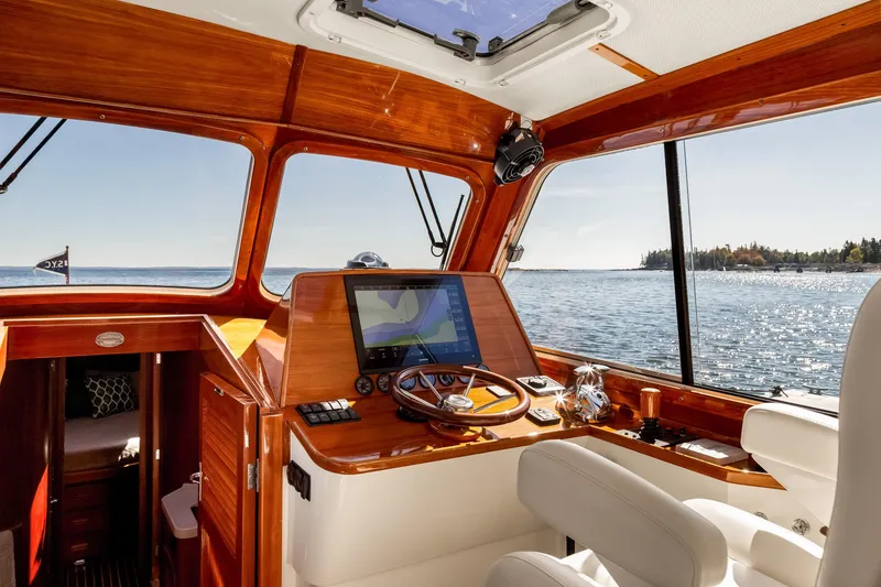 Slide: The Image of Interior view of 2002 Hinckley Talaria 44 Express yacht with wooden dashboard and scenic ocean view. - 26
