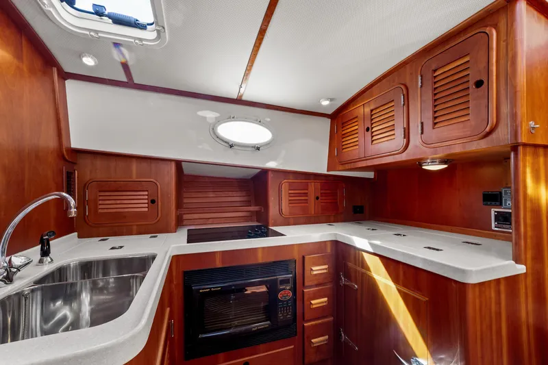 Slide: The Image of Luxurious 2002 Hinckley Talaria 44 Express yacht kitchen with wood cabinetry and modern appliances. - 33