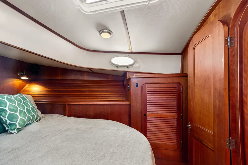 Slide: The Image of Luxurious 2002 Hinckley Talaria 44 Express cabin with elegant wood finish and cozy bedding. - 44