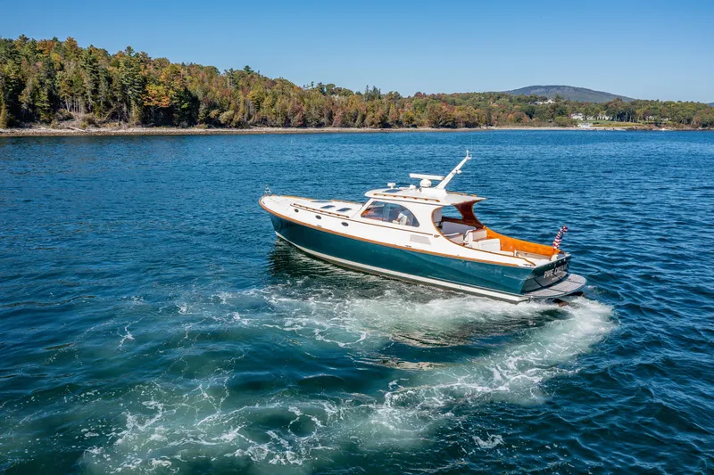 Slide: The Image of 2002 Hinckley Talaria 44 Express cruising on a scenic lake with forested shoreline. - 10