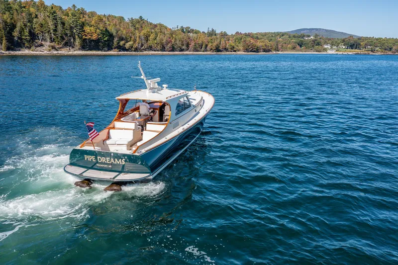 Slide: The Image of 2002 Hinckley Talaria 44 Express yacht cruising on a scenic lake. - 13